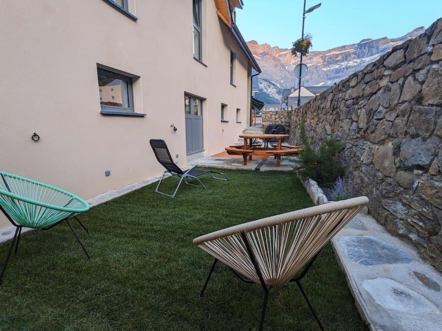 a yard with two chairs and a table and a building at Gîte Le Cerbillona- Gavarnie, France in Gavarnie