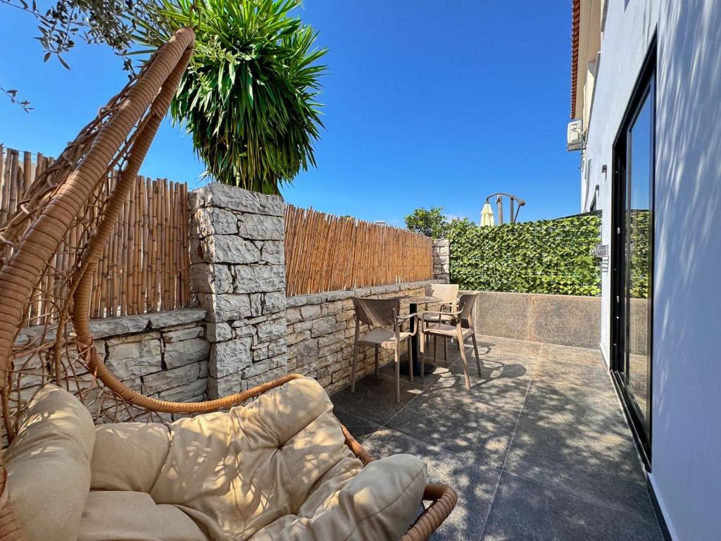 a patio with a couch and a table and a fence at Zace Studios in Ksamil