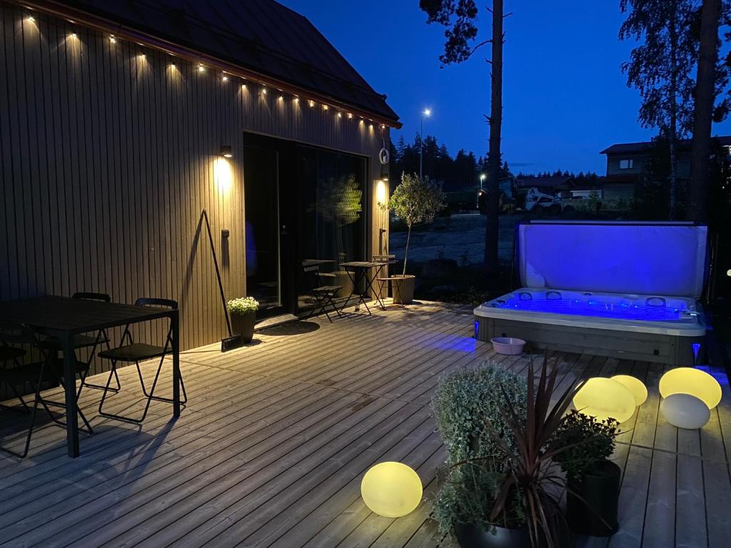 a patio with a couch and a table and lights at Guesthouse with Sauna & Jacuzzi & Cold Water Tub in Nokia