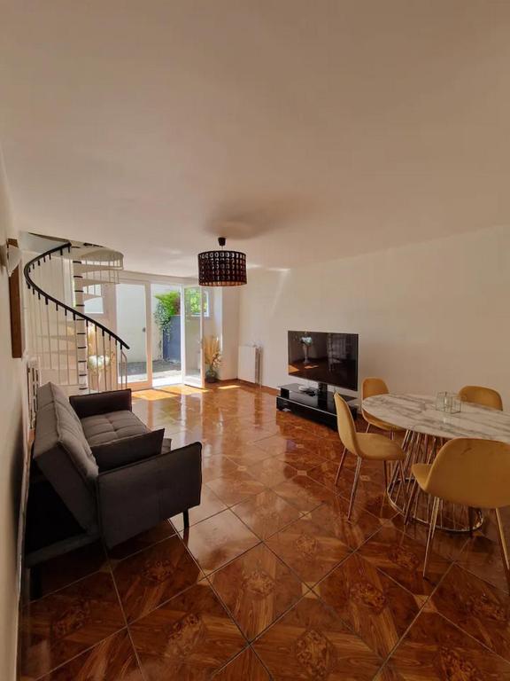 ein Wohnzimmer mit Sofa und Tisch in der Unterkunft 3 cosy bedrooms shared house with 4 beds near Paris in Deuil-la-Barre