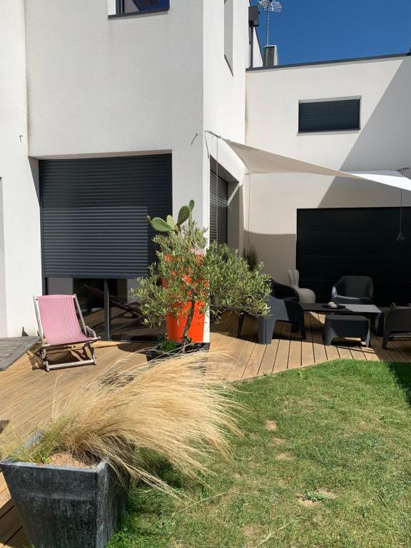une arrière-cour avec une terrasse meublée de chaises et de plantes dans l'établissement maison 3 chambres proche ile de Ré, centre ville, à Puilboreau
