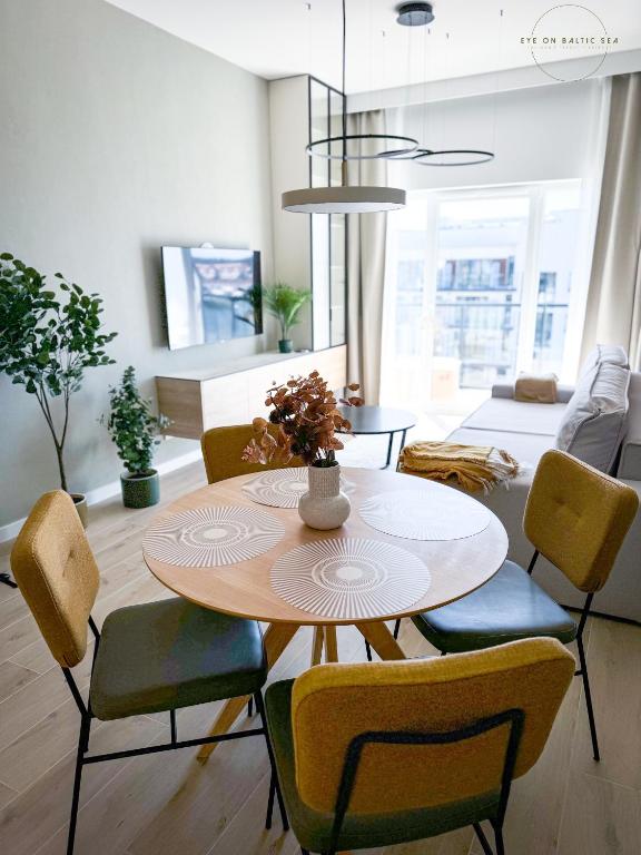 ein Wohnzimmer mit Tisch und Stühlen in der Unterkunft Brand-New Apartment EYE ON BALTIC SEA Luxurious Spa Escape in Dziwnów with Stunning Views in Dziwnów