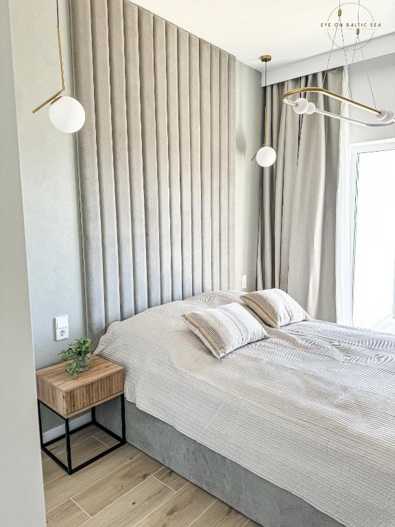 Ein Bett oder Betten in einem Zimmer der Unterkunft Brand-New Apartment EYE ON BALTIC SEA Luxurious Spa Escape in Dziwnów with Stunning Views