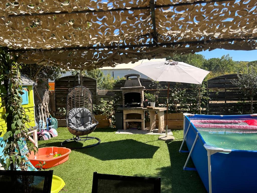 une arrière-cour avec une piscine, une table et un parasol dans l'établissement Jolie maison familiale, à Tourrettes