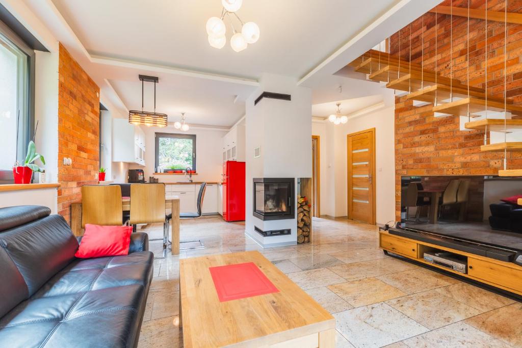 a living room with a couch and a fireplace at Łasko - Wildlife Phototherapy 4 klimatyzowane wille, po 100m2, z dostępem do prywatnego stawu, ogrodu 2ha in Bierzwnik