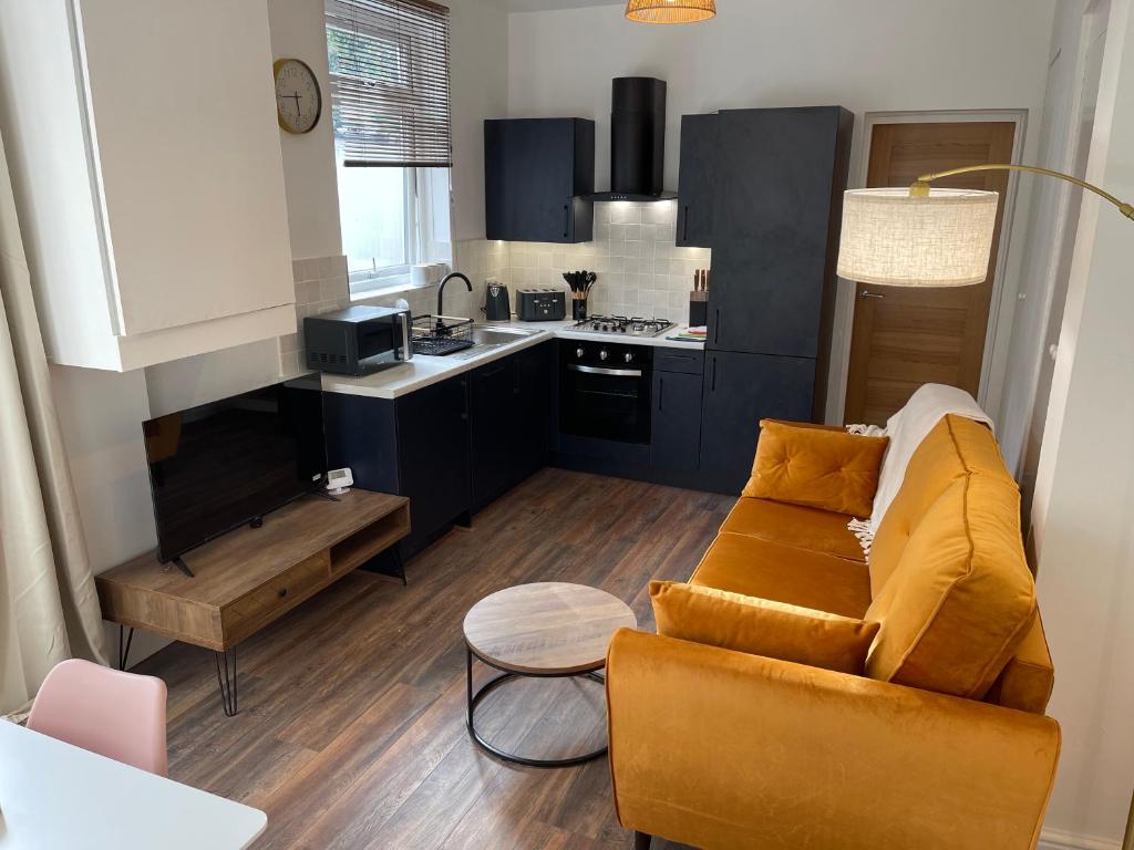 a living room with a couch and a kitchen at Flat 2, 297 Gillott Road, B16 0RT in Birmingham