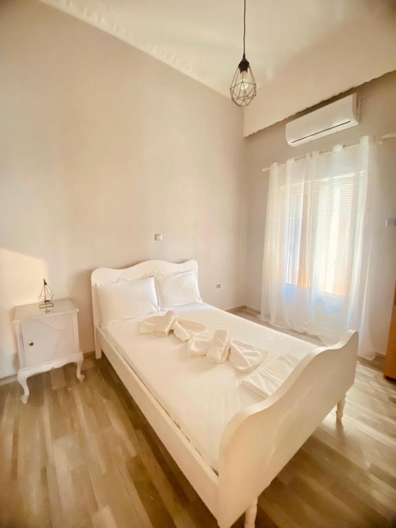 a white bed in a room with a window at Porto Levante Anemos in Ermoupoli