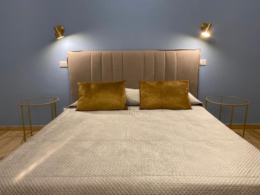 a bedroom with a large bed with two chairs at La Zisa Luxury Apartment in Palermo