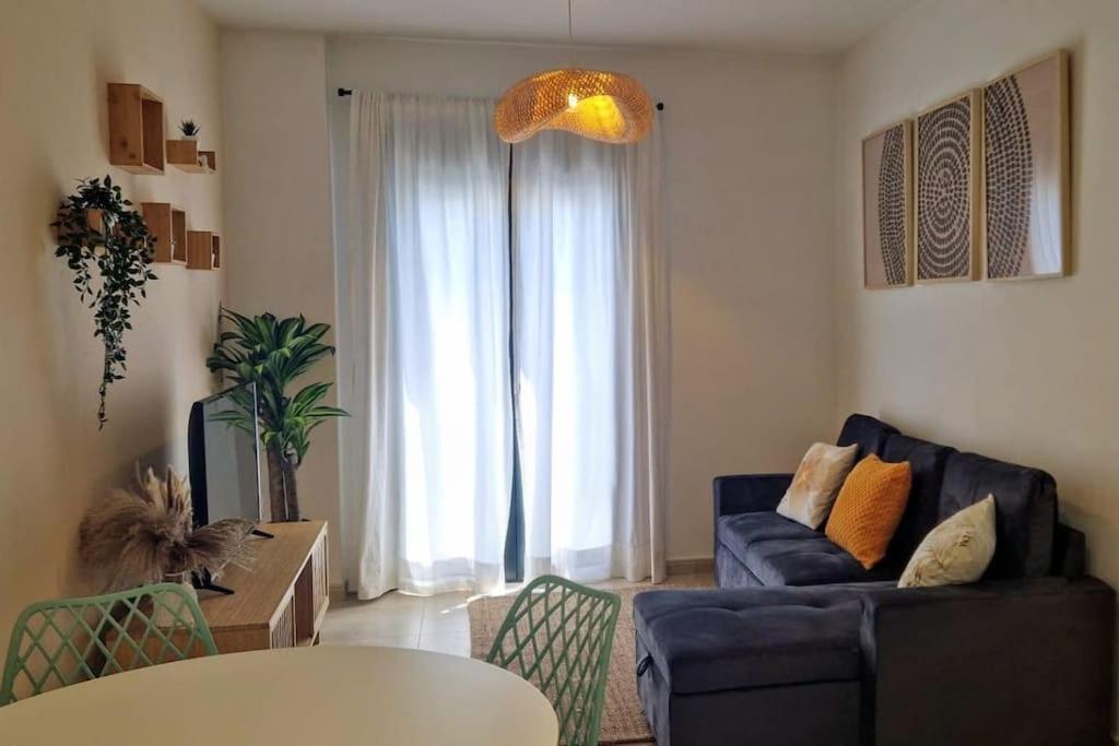 a living room with a blue couch and a table at Dúplex Chiclana Centro con Terraza y Parking By Chiclana Dreams in Chiclana de la Frontera