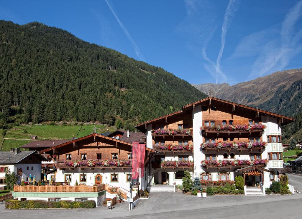 a large building with people sitting on the balconies of it at Appartementhaus zum Holzknecht am See in Neustift im Stubaital