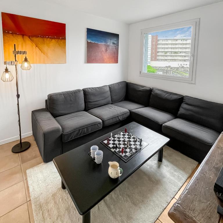 - un salon avec un canapé et un échiquier sur une table dans l'établissement Confort et Style aux Portes de Paris, à Saint-Ouen