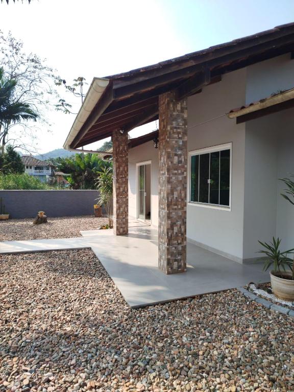 a house with a brick pillar in a yard at Suítes Garden in Pomerode