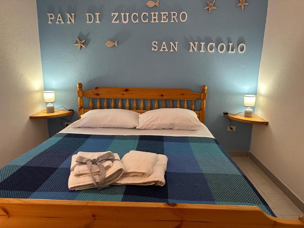 a bedroom with a bed with towels on it at Villaggio Malfidano in Buggerru