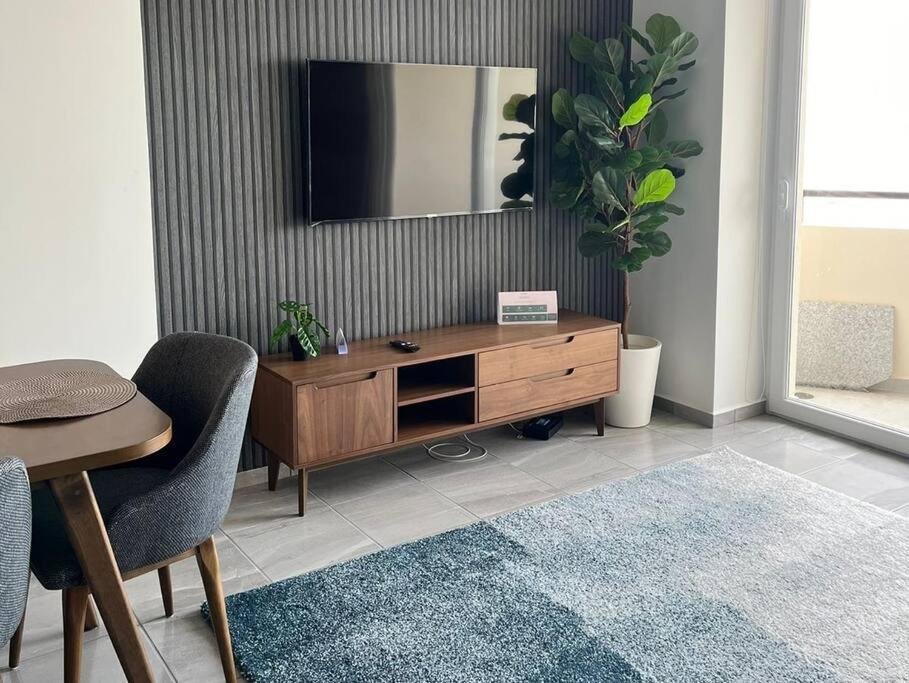 a living room with a wooden dresser with a mirror at Departamento con vista al mar en Cabo Marino in Conchal