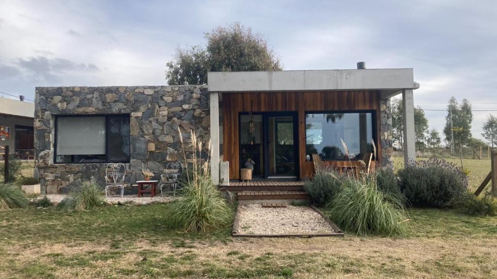 a small house with a stone wall at Casita Petra in Tandil