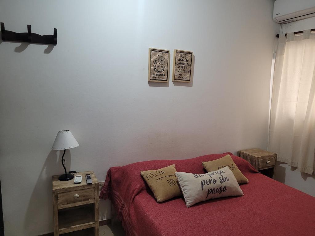 a living room with a red couch with two pillows at Depto Céntrico II in Corrientes