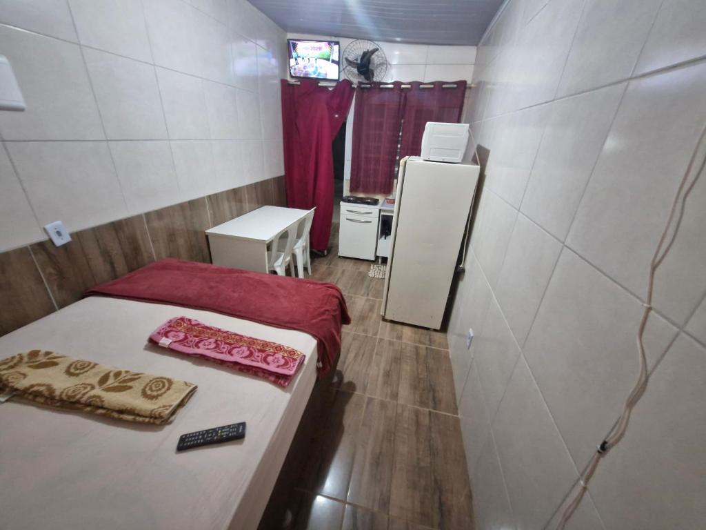 a small room with a bed and a refrigerator at Hospedaria Cmc unidade 04 in Brasilia