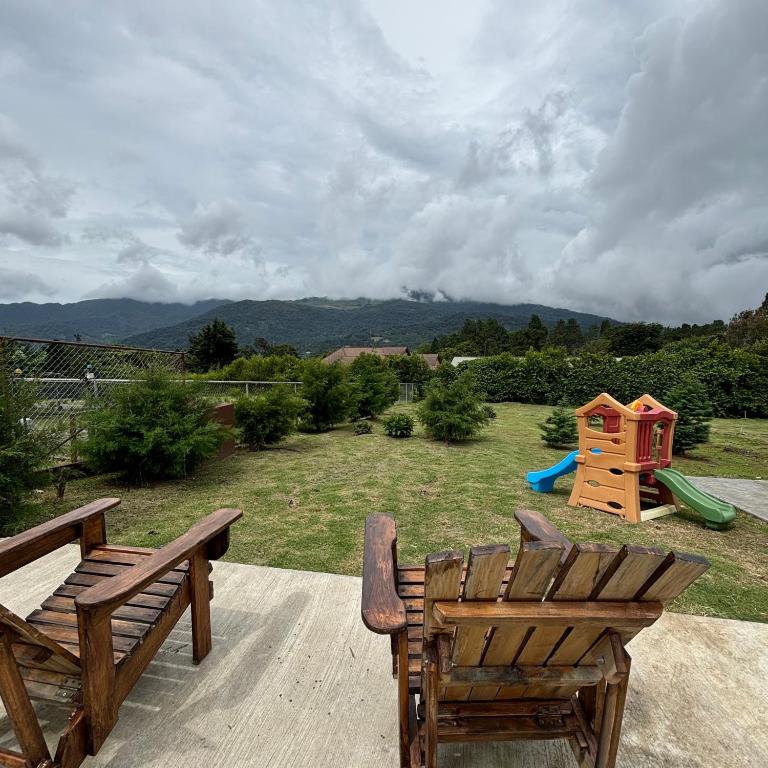 un patio con 2 sedie e un cortile con parco giochi di Casa mirador a Boquete