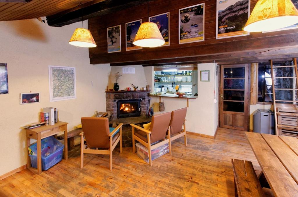 a living room with a table and a fireplace at Refugi Rural Vall de Siarb in Llagunes