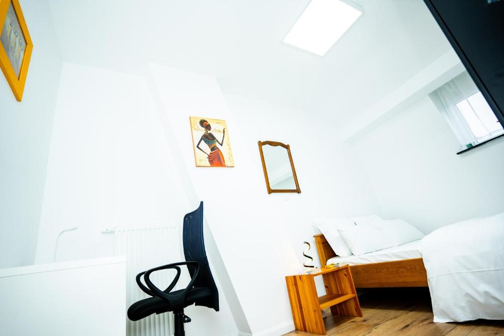 a bedroom with a bed and a chair at Chambre R2 avec salle de bain partagée près de l'hôpital de la Citadelle à Liège in Liège