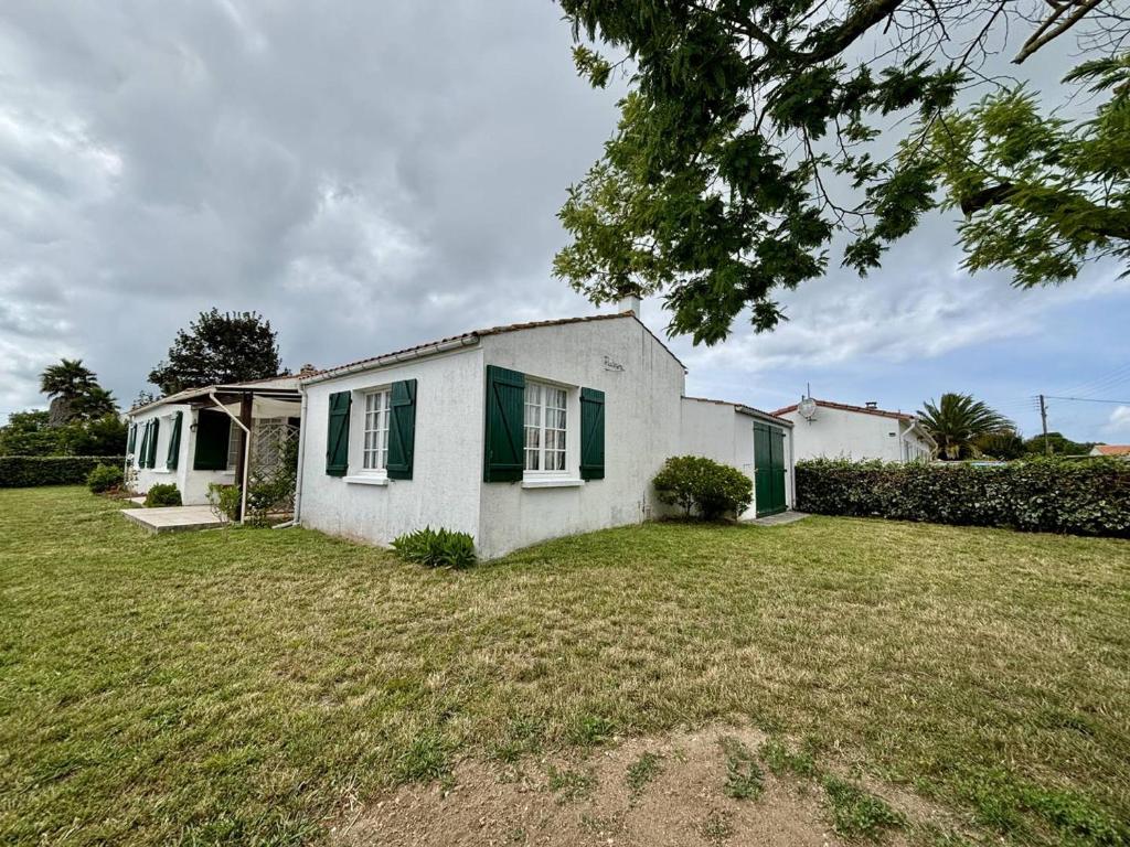 une maison blanche avec volets verts sur une cour dans l'établissement Maison Oléron 6 pers, plage 400m, jardin, parking - FR-1-246A-329, à Saint-Denis-dʼOléron