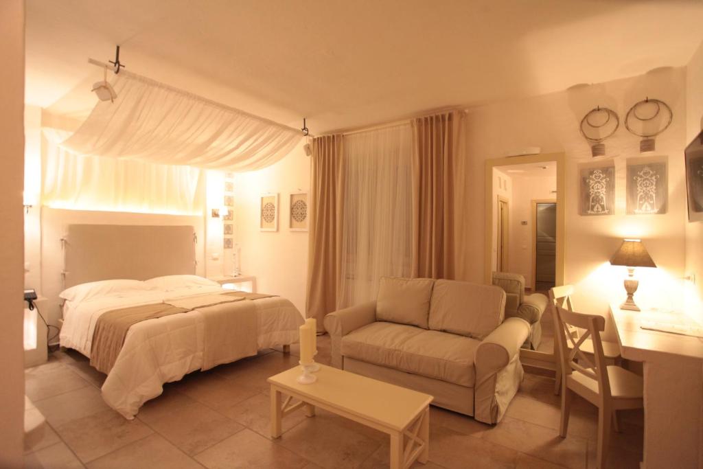 een slaapkamer met een bed, een bank en een tafel bij Relais in Contrada in Lucera