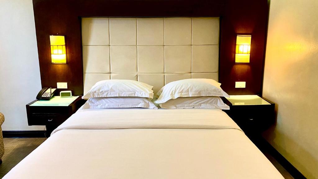 Postel nebo postele na pokoji v ubytování Circle Inn Hotel and Suites Bacolod