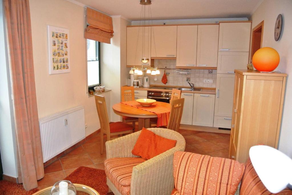 a living room with a table and a kitchen at Villa Laura 12 in Kühlungsborn