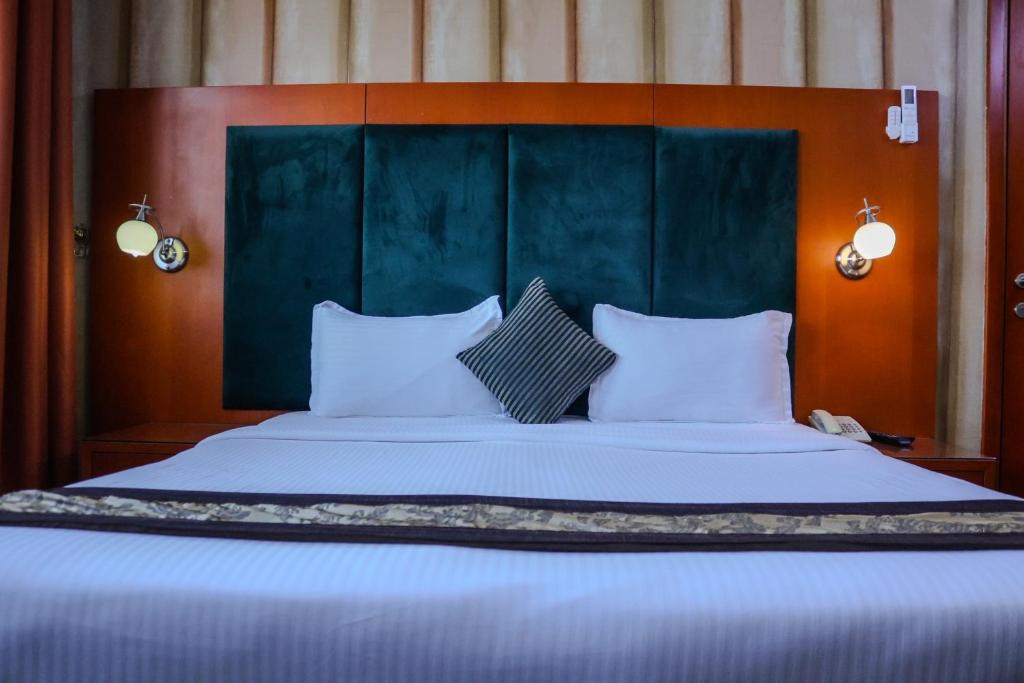 Postel nebo postele na pokoji v ubytování BOONMAX Hotel