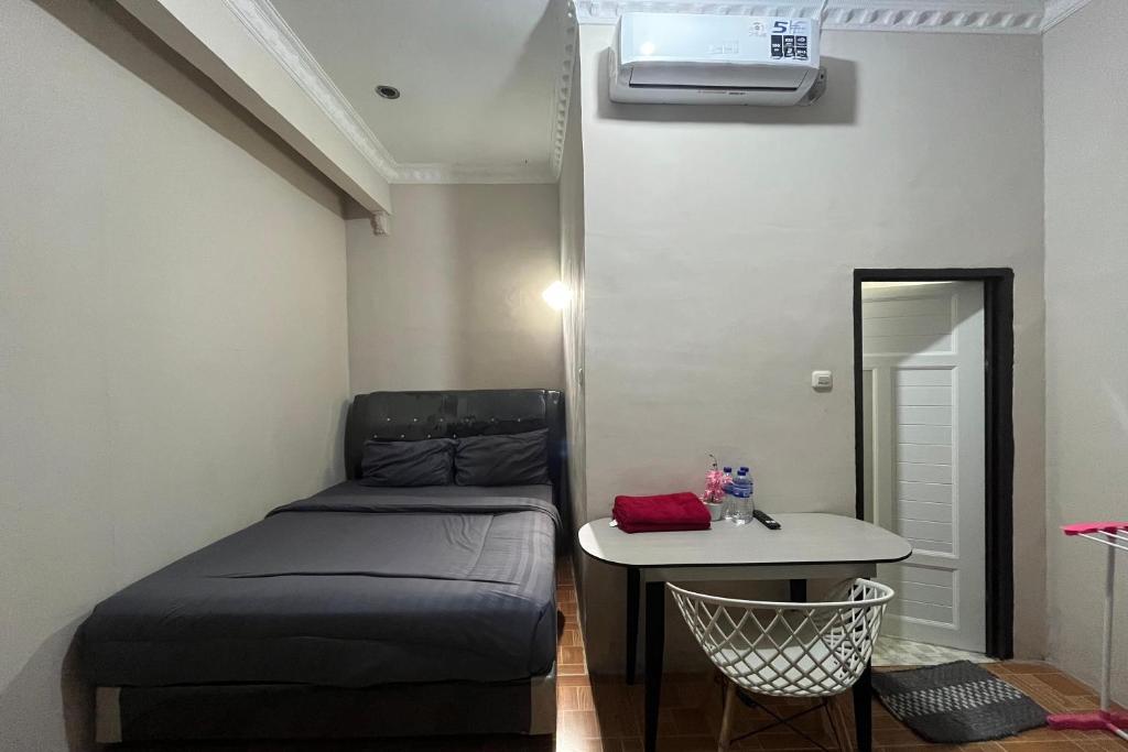 a small bedroom with a bed and a table at Pondok Family in Pangandaran