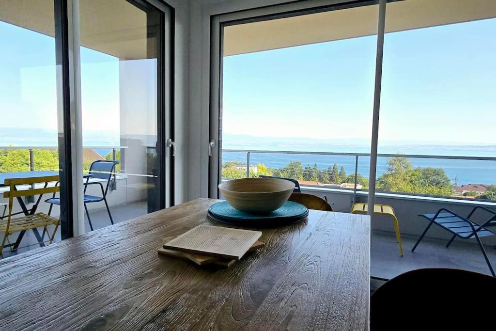 - un bol sur une table en bois dans une chambre avec fenêtres dans l'établissement L'Horizon Léman, à Évian-les-Bains