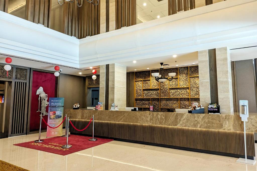 a lobby of a hotel with a reception desk at Swiss-Belhotel Airport Yogyakarta in Yogyakarta