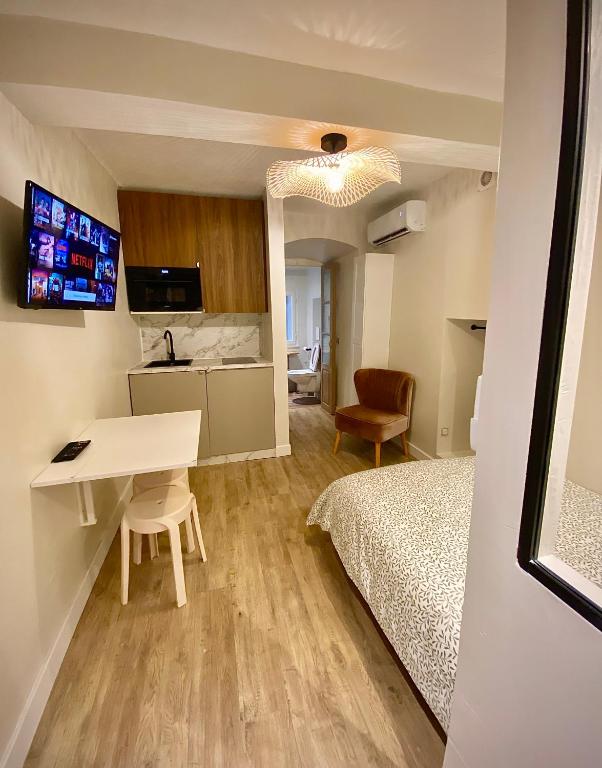 une chambre avec un lit, un bureau et une table dans l'établissement Charmant studio hyper centre, à Bastia