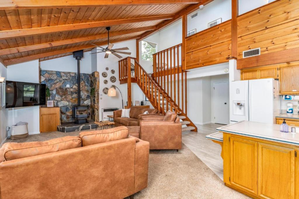 a living room with couches and a kitchen at Hodges Hill Hideout w/ pool, spa, BBQ - Dog Friendly in Oakhurst