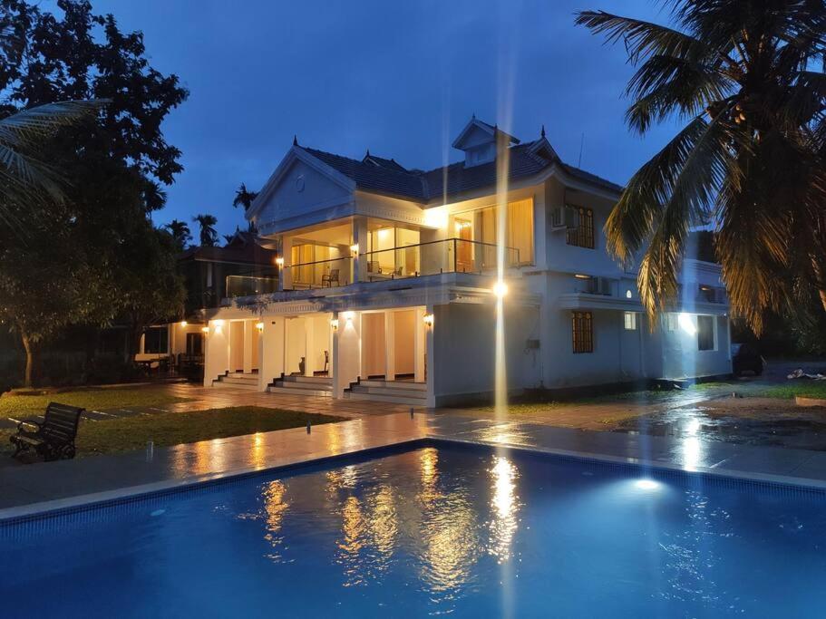 a large house with a swimming pool in front of it at Riveria Portico - River side 6 bedroom private pool Bungalow in Parūr
