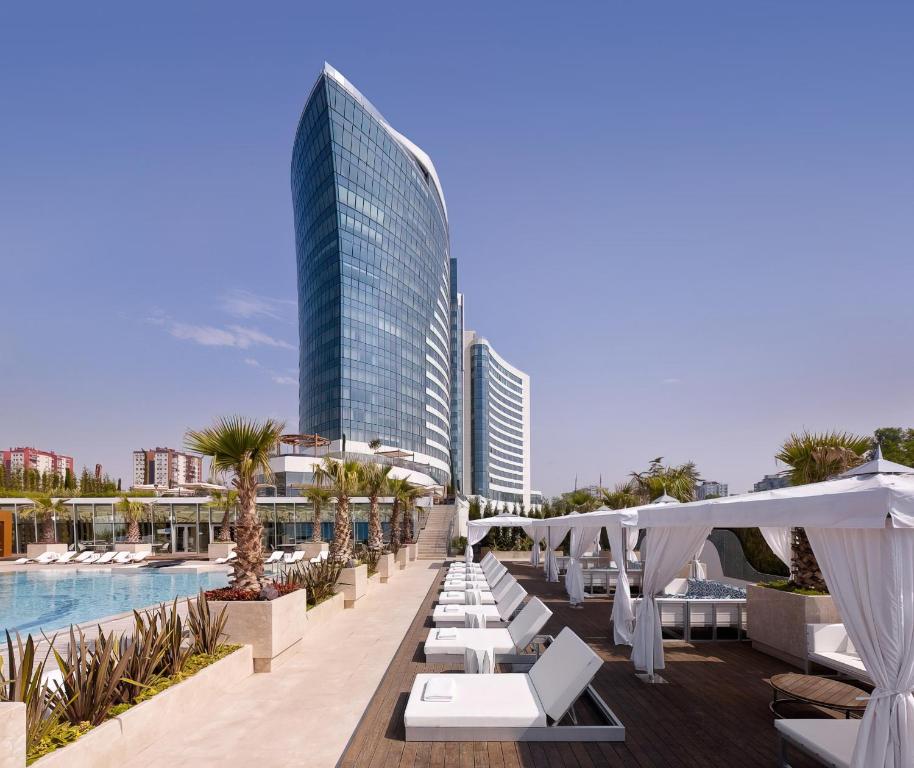 a hotel pool with white lounge chairs and a building at Hyatt Regency Istanbul Atakoy in Istanbul