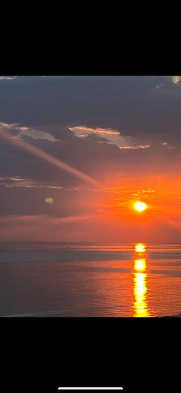 un coucher de soleil sur l'océan avec le soleil dans le ciel dans l'établissement Studio face mer pieds dans l’eau, à Saint-Hilaire-de-Riez