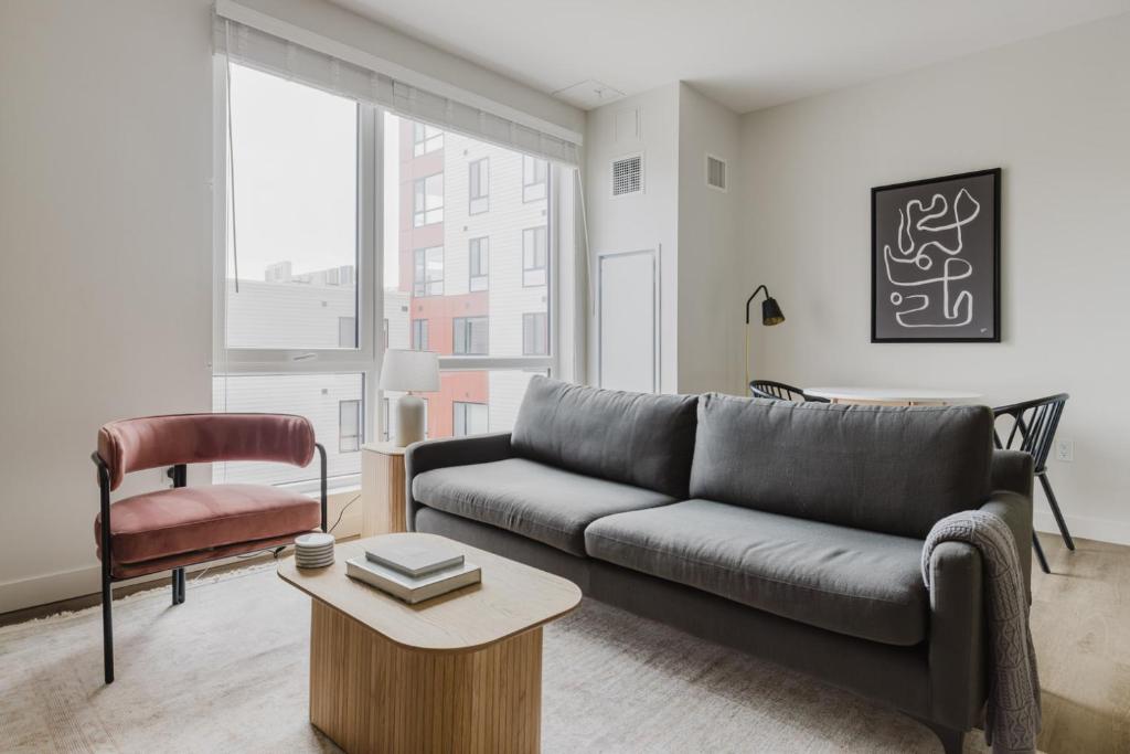 a living room with a couch and a chair at Blueground Revere spa gym pool wd lounge BOS-1100 in Boston