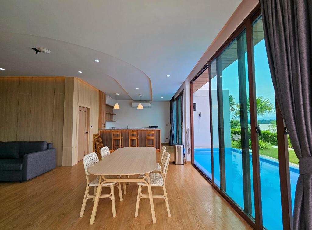a dining room and living room with a table and chairs at Sunrise Resort & Cafe - ซันไรส์ รีสอร์ท & คาเฟ่ in Nakhon Phanom