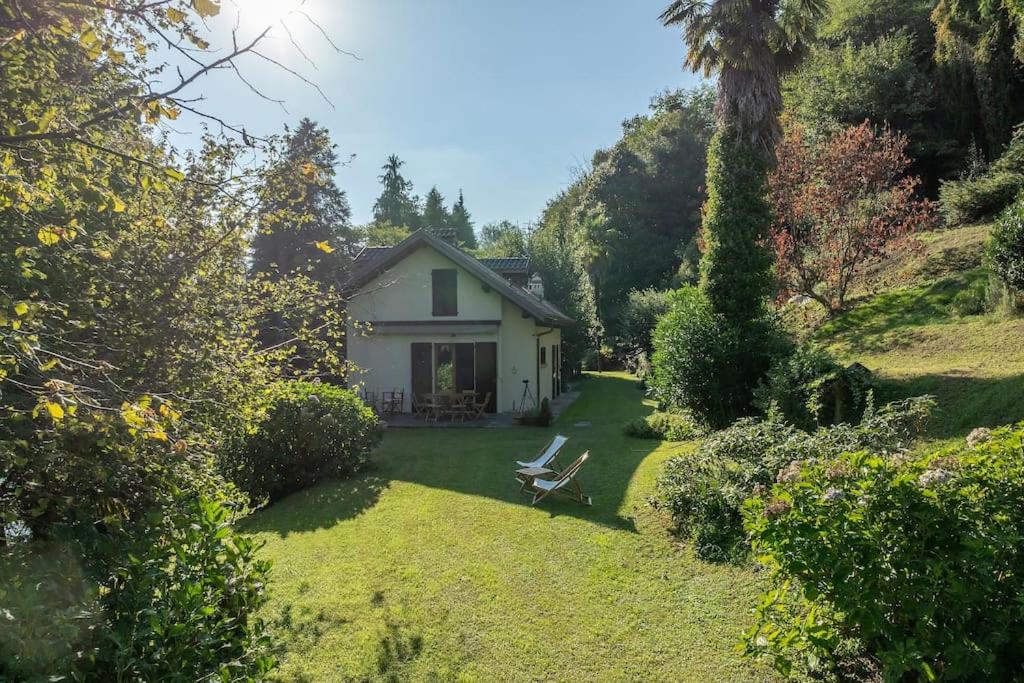 ein weißes Haus mit einer Bank im Hof in der Unterkunft Casa Giuliana casa con giardino privato in Orta San Giulio