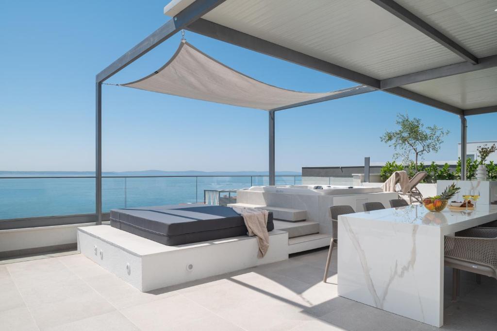 a bedroom with a bed and a table on a balcony at Penthouse La Vie with seaview and jacuzzi in Podstrana