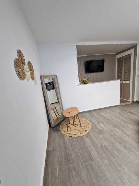 Cette chambre comprend une table, un tabouret et un miroir. dans l'établissement La Sauvagerie, à Le Portel