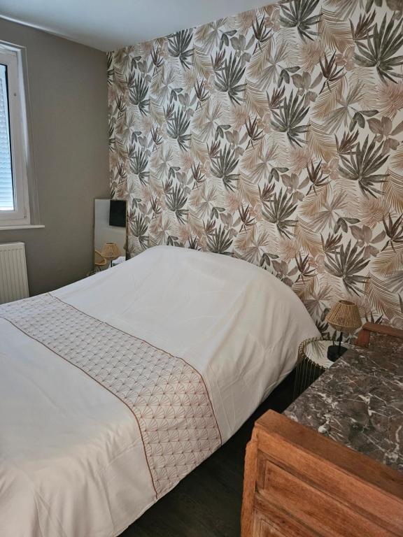 a bedroom with a bed with a floral wallpaper at La Sauvagerie in Le Portel