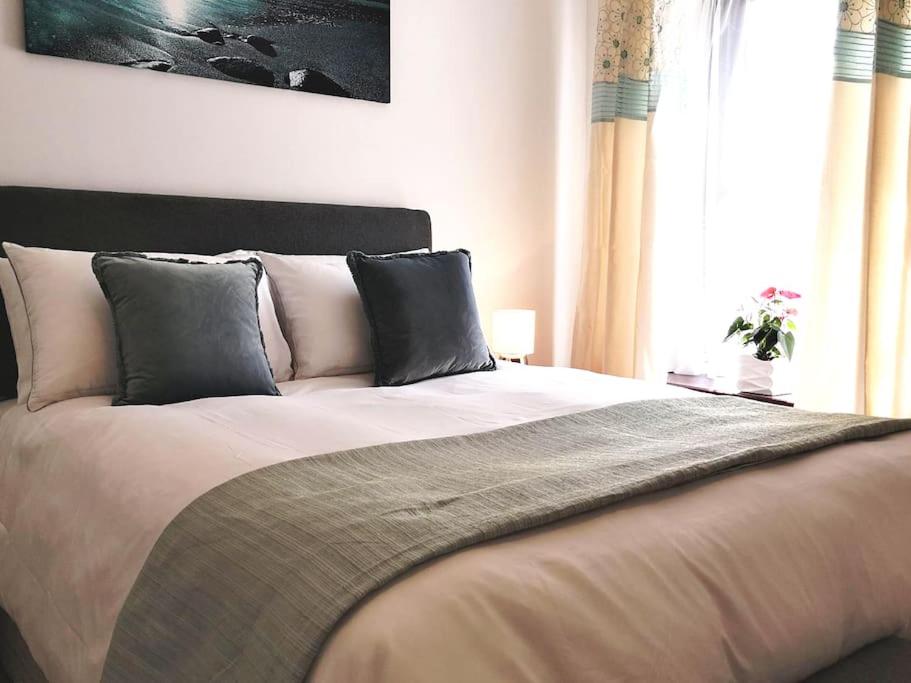 a bedroom with a large bed with pillows and a window at Estuary View Bank House Stunning apartment in Millom