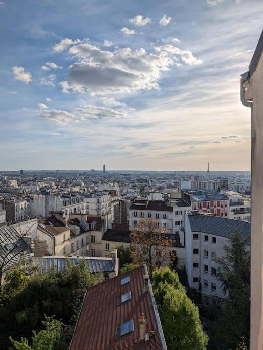 une vue sur une ville avec des bâtiments et des nuages dans l'établissement Petit Simple Studio In Paris Romainville Carnot, à Romainville