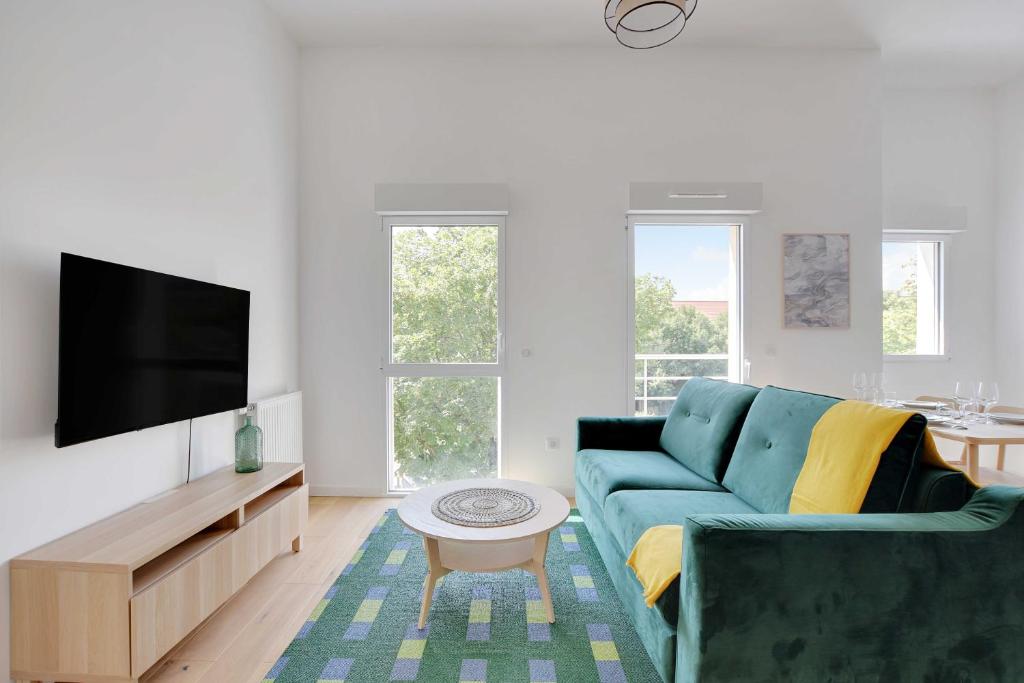Una sala de estar con un sofá azul y un televisor en Modern Apartment - 1BD-4P - PMR - Nogent-sur-Marne, en Nogent-sur-Marne