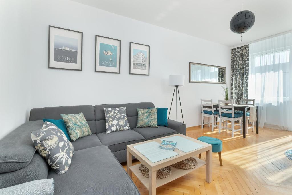 a living room with a couch and a table at Stylowe Apartamenty w Centrum Gdyni i Blisko Plaży by Noclegi Renters in Gdynia