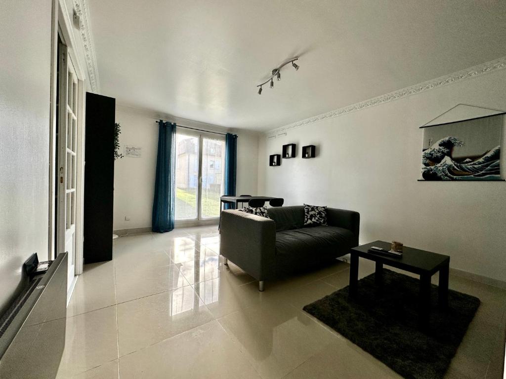 a living room with a couch and a table at Appartement Confort à Louvres proche CDG in Louvres