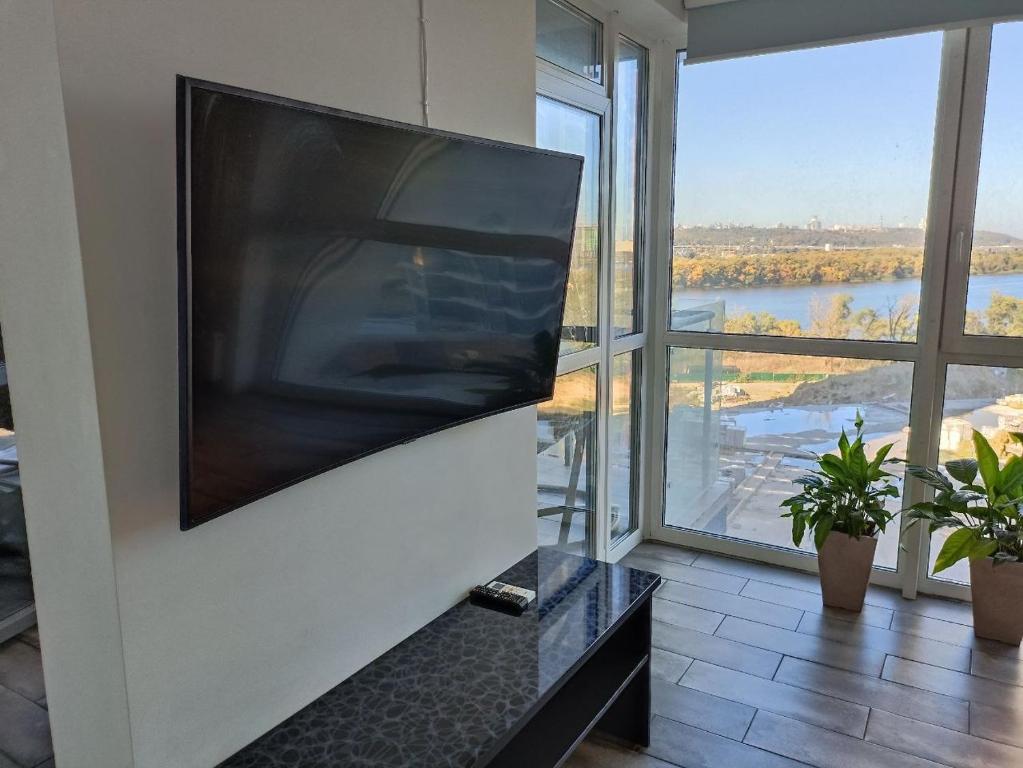 a large flat screen tv hanging on a wall in a room at 4 rooms apartment with a view of the Dnieper River in Kyiv
