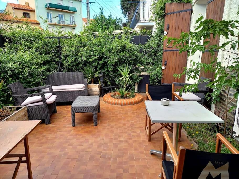 d'un patio en briques avec des tables et des chaises. dans l'établissement T2 climatisé avec jardin privatif et stationnement, à Perpignan